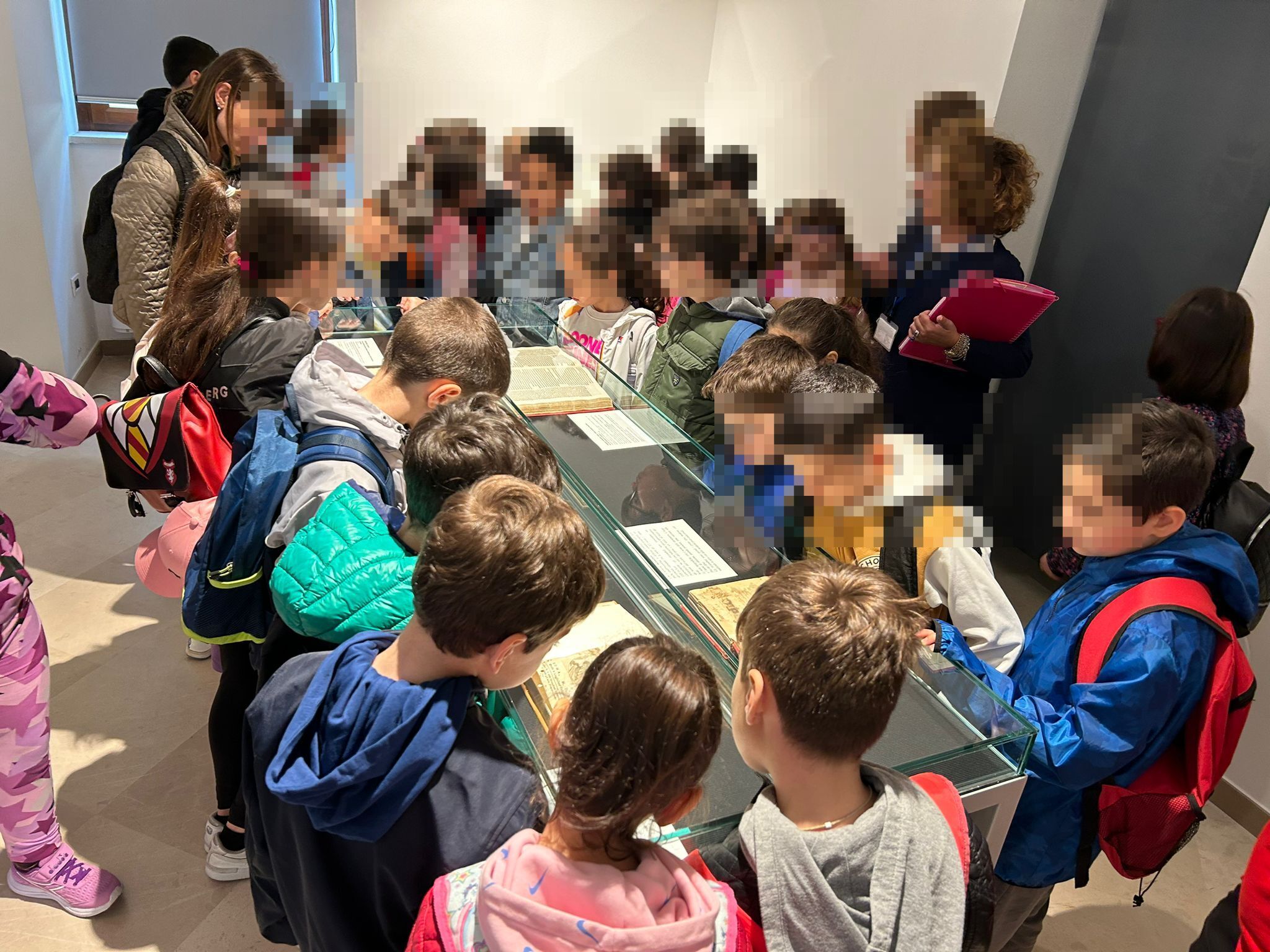 Alunni osservano libri manoscritti