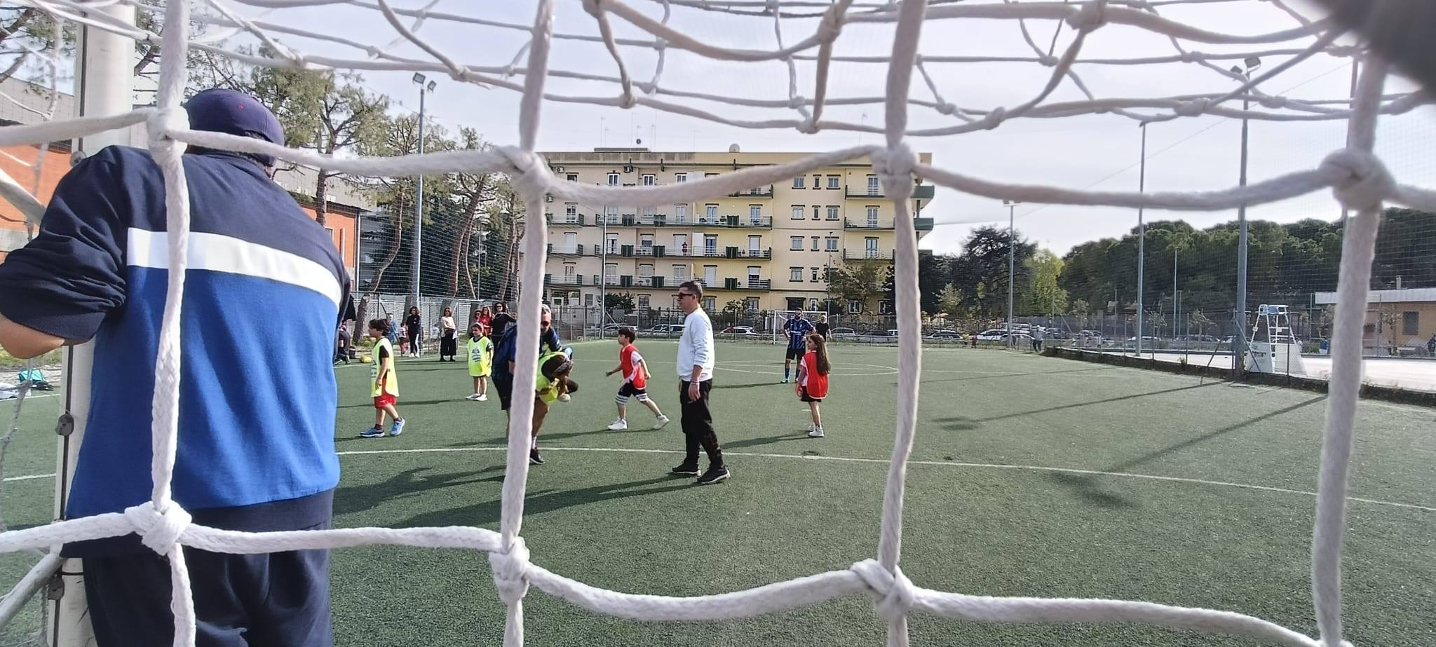 Bambini giocano a calcetto con i loro papà